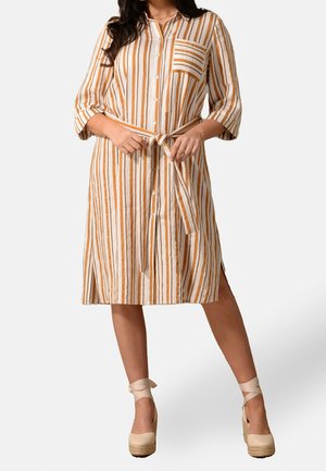 Gestreiftes Leinenkleid in Elfenbein und Orange mit durchgehender Knopfleiste, Taillengürtel und seitlichen Schlitzen. Verfügt über eine Brusttasche und dreiviertellange Ärmel.
