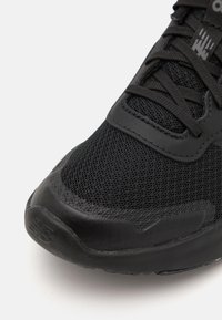 Czarne buty sportowe z siateczkową cholewką, teksturowaną gumową osłoną palców oraz płaskimi sznurowadłami, z delikatnym logo na bocznej części i języku.