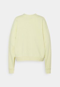 Sweatshirt jaune clair, raccourci, à manches longues, avec poignets côtelés et col rond. Texture lisse, design minimaliste, sans motifs visibles.