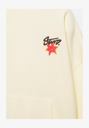 Sweat crème avec poche avant, texte noir stylisé "STWD." au-dessus d'une fleur rouge et orange en haut à gauche.