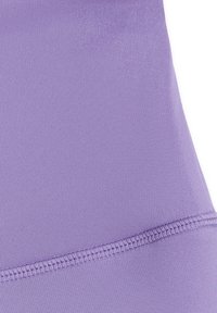 Gros plan d'un tissu violet clair avec des coutures visibles et un motif tricoté texturé, montrant le détail de la couture et du tissage du matériau.