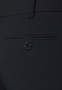 Czarne spodnie z tylną kieszenią zapinaną na guzik oraz delikatnym przeszyciem, wykonane z gładkiego materiału o subtelnej fakturze.