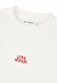 Biały, prążkowany bawełniany t-shirt z okrągłym dekoltem i czerwonym napisem "LOVE SEASON" wyszytym na piersi. Etykieta: "OH APRIL."