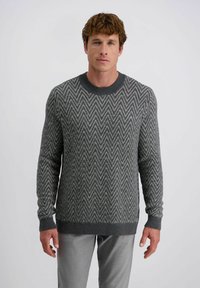 Grijs patroontrui met een zigzagdesign, geribbelde halslijn en manchet. Gecombineerd met lichtgrijze broek. Zachte textuur en comfortabele pasvorm.