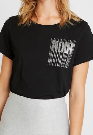 Černé tričko s krátkým rukávem vyrobené z měkké látky, na kterém je stříbrný glitrový design "NOIR" s vertikálními pruhy na levé straně.