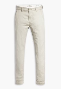 Jasno beżowe chinosy wykonane z bawełny, wąski krój, z zapięciem na guzik i zamek błyskawiczny, standardowe kieszenie boczne oraz staranne wykończenie.