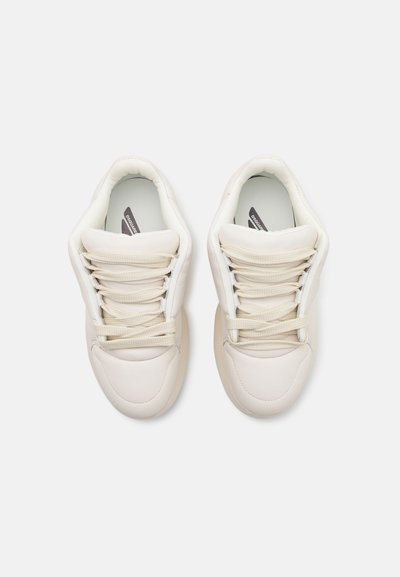 White leather sneakers with textured upper, round toe, and flat laces. Minimalist design with subtle branding on the insoles.