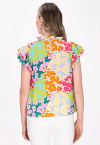 Farverig blomsterbluse med flæseærmer, der har en række lyse nuancer, herunder pink, orange, grøn og gul; letvægtsstof.