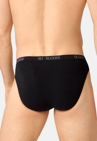 Schwarze Sloggi-Unterhose aus glattem, dehnbarem Stoff. Mit einem elastischen Bund mit Logo und einem klassischen, figurbetonten Design.