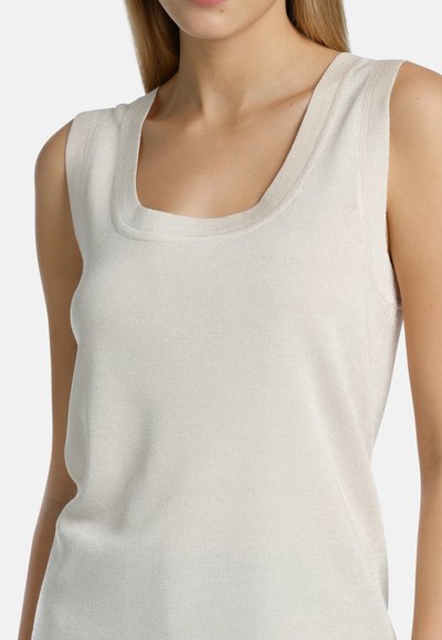 Top sin mangas de color beige claro con escote cuadrado, fabricado en un tejido suave con textura acanalada, que presenta detalles de costura sutiles en el escote.