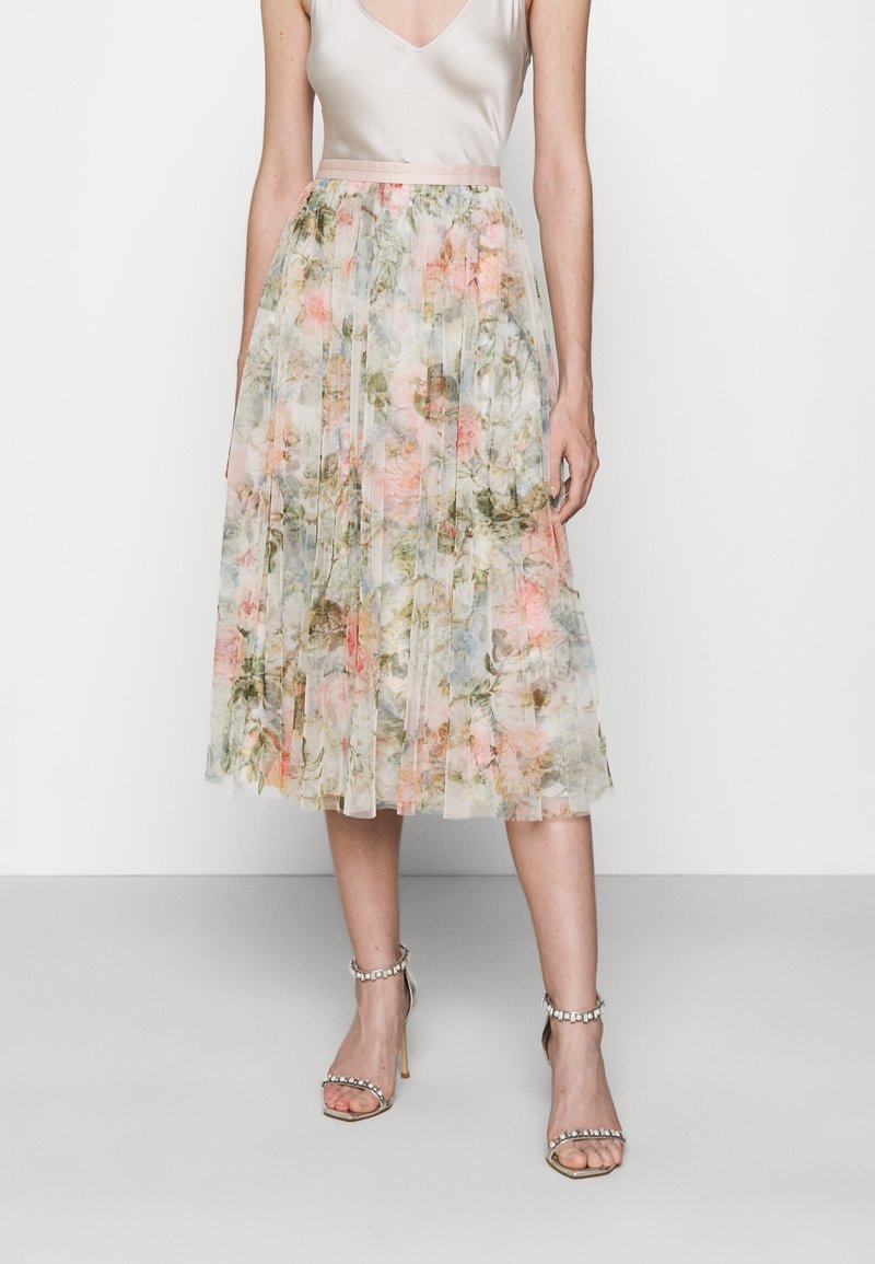 Plissé midirok met bloemen, gemaakt van een licht, doorschijnend stof in pasteltinten. Voorzien van een zachte tailleband en delicate bloemmotieven overal.
