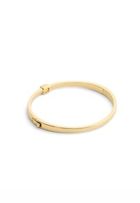 Bracciale rigido in metallo dorato, forma circolare, superficie liscia, caratterizzato da una chiusura a incastro con un design elegante e minimale.