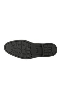 Black rubber shoe sole with textured pattern and raised sections for grip. Features smooth edges and an embossed logo in the center.