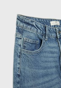 Denim jeans in light blue with a faded texture, featuring a traditional five-pocket design and a waist with a metal button closure.