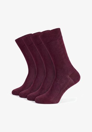 Vier Paar schlichte dunkelviolette Crew-Socken ordentlich nebeneinander auf weißem Hintergrund.