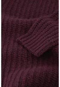 Burgunderfarbener Strickpullover mit gerippter Textur, dicken Bündchen und einem gemütlichen, weichen Finish. Schwerpunkt auf dem Garnmuster und der Materialtiefe.