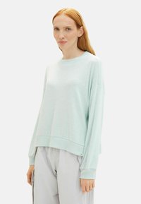 Pulover bărbătesc ușor din tricot, de culoare verde mentă, cu guler rotund și croială lejeră. Dispune de manșete și tiv cu nervuri, precum și umeri căzuți pentru confort.