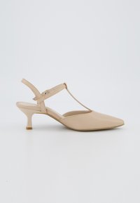 Chaussure slingback beige à bout pointu en matériau lisse, avec une fine bride et un petit talon rond. Design minimaliste aux lignes épurées.