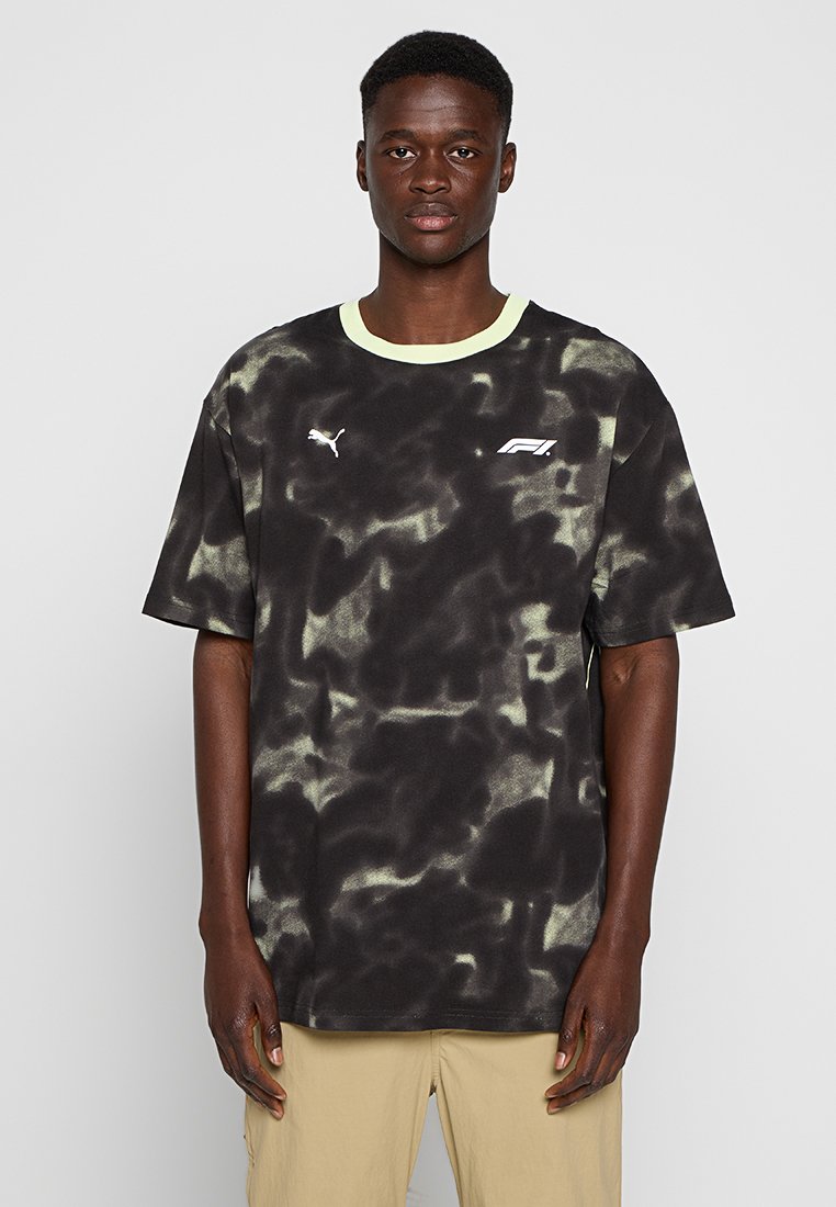 T-shirt tie-dye noir et vert avec un col rond, des manches courtes et un logo graphique sur la poitrine. Fabriqué en tissu doux avec une coupe décontractée.