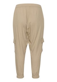 Pantaloni cargo beige con cintura elastica, polsini affusolati, tasche laterali e un tessuto intrecciato testurizzato.