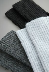 Zestaw trzech kawałków dzianiny o fakturze, w kolorach ciemnoszarym, grafitowym i jasnoszarym, z prążkowanym wzorem dla dodatkowej głębi.