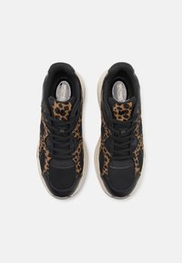 Baskets noires avec accents imprimé léopard, matériaux en mesh texturé et cuir, bout rond, semelle en caoutchouc, avec fermeture à lacets et logo.