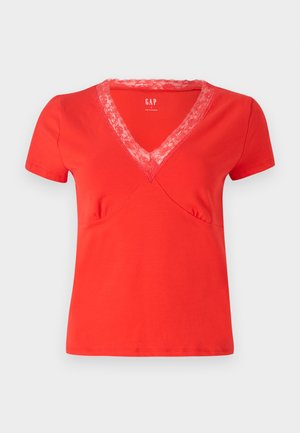 T-shirt vermelha de mangas curtas e decote em V com um acabamento em renda. Tecido suave, forma ajustada e costura decorativa ao longo das costuras.