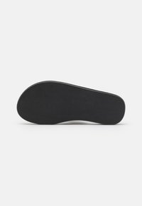Svart gummisula med en slät, matt finish och en rundad, ergonomisk form; har en minimalistisk design och inga synliga mönster.