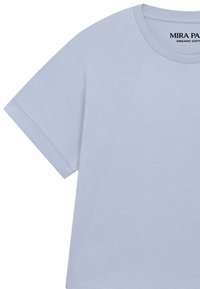 T-shirt bleu clair en coton biologique à manches courtes avec col rond et « MIRA PAR » imprimé à l'intérieur du col.
