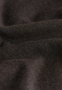 Dark brown fabric with a smooth, textured weave, showing subtle variations in density and light reflection across the surface.