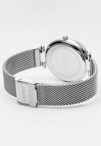 Orologio da polso con bracciale in rete argentata e cassa rotonda. Presenta un design minimalista, una texture metallica lucida e una chiusura incisa con la scritta "Esprit".