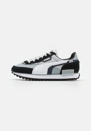 Athletic sneakers featuring a black, white, and gray design. Made of suede and mesh with a textured sole and prominent logo on the side.