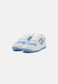 Baskets blanches avec des accents bleu clair, en cuir synthétique, dotées de bouts perforés, de lacets à l'avant et de semelles en caoutchouc texturé.