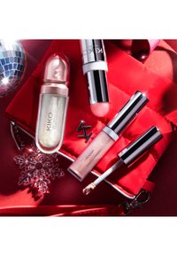 Nel punteruolo rosso trapuntato ci sono quattro prodotti cosmetici Kiko Milano: un illuminante liquido luccicante, un illuminante in stick cremoso e due ombretti liquidi.