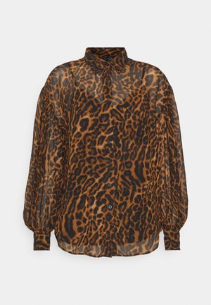 Blouse à manches longues boutonnée avec imprimé léopard marron et noir et col pointu, fabriquée en tissu transparent.