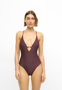 Maillot une pièce en bordeaux foncé avec un décolleté en V profond. Il présente un motif de vagues rose clair et un petit détail accentué à l'avant.