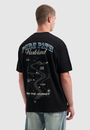 Zwarte katoen t-shirt met een grafisch ontwerp op de achterkant, dat een kronkelige weg met bergen, tekst en steraccenten in verschillende kleuren afbeeldt.