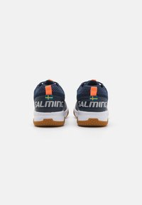 Adidași navy cu un superior texturat, talpă intermediară albă și accente portocalii. Prezintă un steag suedez și un logo proeminent "SALMING" pe toc.