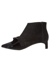Bottines noires avec une texture scintillante, bout pointu, petit talon carré et un accent de nœud proéminent sur le côté.