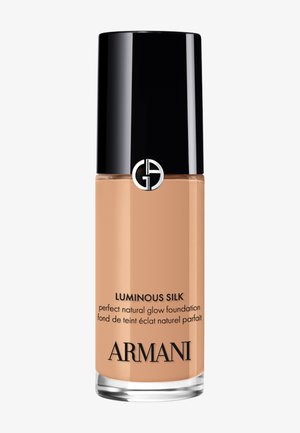 Flacon de fond de teint Armani Luminous Silk effet glow naturel avec un bouchon noir et un liquide beige visible à l'intérieur.
