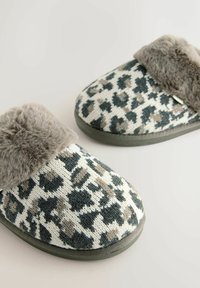 Leopard print slippers in beige, black, and gray knit with a soft gray faux fur cuff and textured rubber sole. Rounded shape, cozy design.