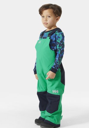 Jardineros infantiles en verde y azul marino con tirantes ajustables, fabricados con material duradero. Presentan un detalle de logo y puños elásticos.