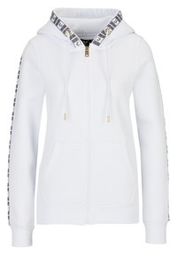 Bílá mikina na zip s podšitou kapucí, zlatými kovovými doplňky a černými vzorovanými prvky podél rukávů. Má přední kapsu a žebrované manžety.