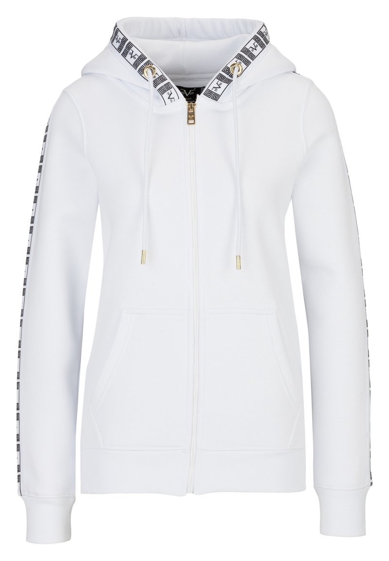 Bílá mikina na zip s podšitou kapucí, zlatými kovovými doplňky a černými vzorovanými prvky podél rukávů. Má přední kapsu a žebrované manžety.