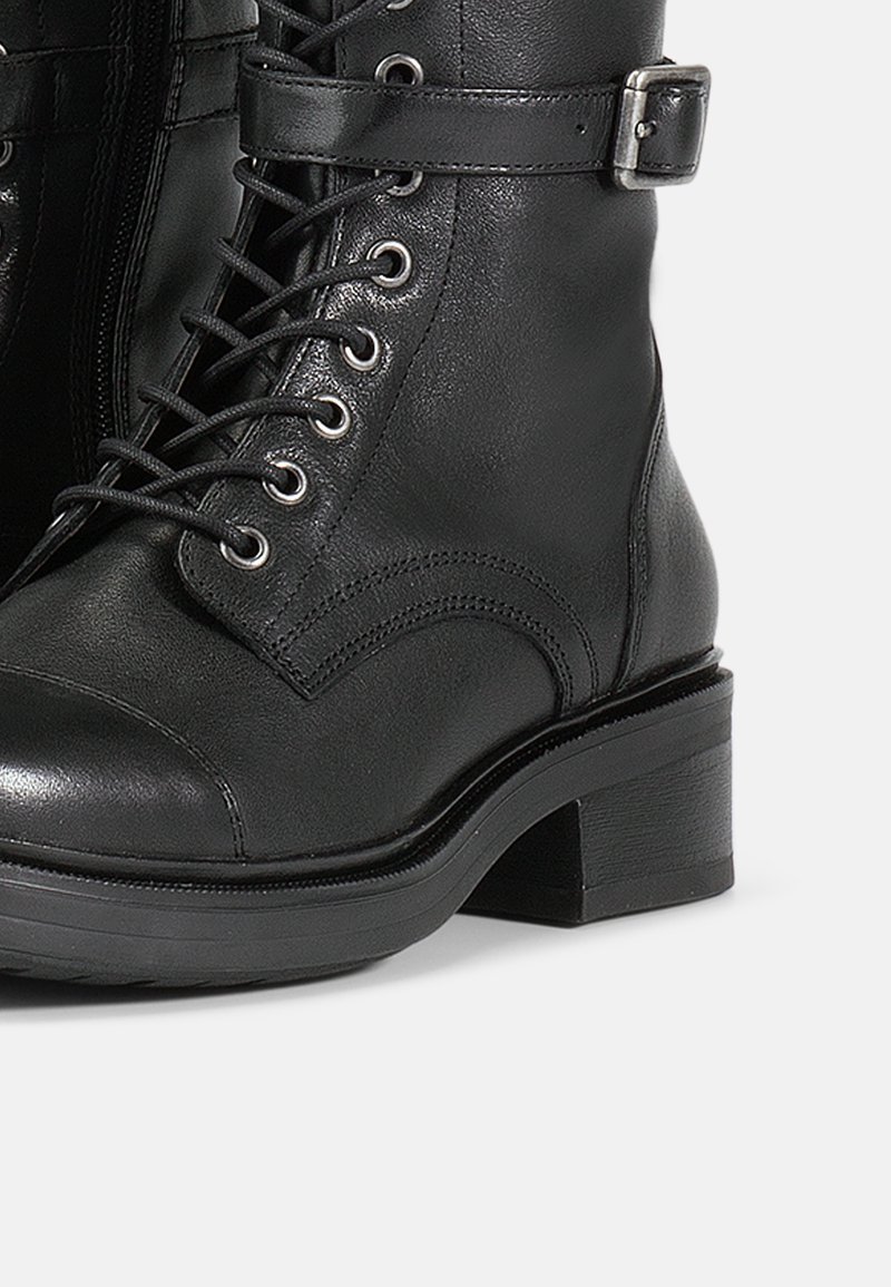 Schwarze Leder-Stiefelette mit runder Zehenpartie, Schnürverschluss, seitlichem Reißverschluss, verstellbarem Riemen mit metallischer Schnalle und Blockabsatz.