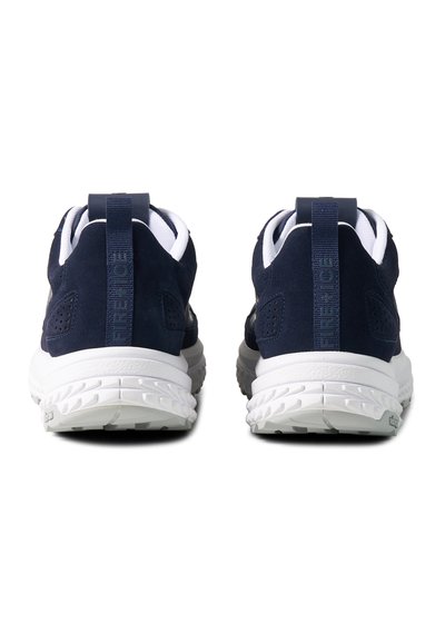 Pair of navy blue and white sneakers shown from the rear, featuring thick white soles and navy pull tabs with text branding.