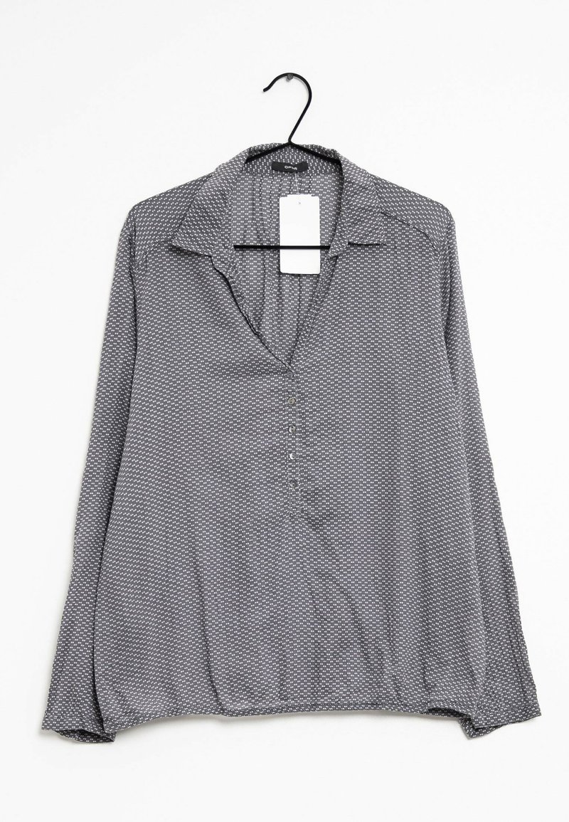 Blusa grigia con colletto, maniche lunghe e chiusura a bottoni; presenta un motivo geometrico bianco e una superficie liscia.
