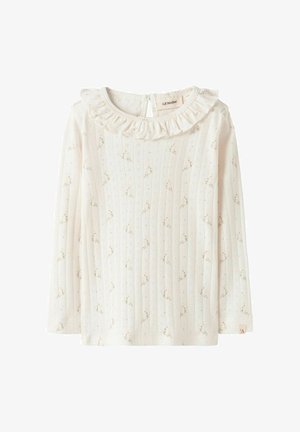 Kremfarvet langærmet ribbet top med lille beige blomsterprint og flæsekant ved halsen, knappelukning med hul bag på nakken.
