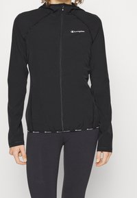 Sort zip-up hoodie lavet af letvægtsstof, med en tætsiddende pasform, hætte og elastisk talje med logo detaljer.