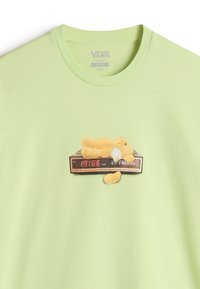 Limegrøn T-shirt med en blød gul bjørnegrafik på et sort vækkeur, der viser tiden "19:66" med røde cifre. Klassisk pasform.
